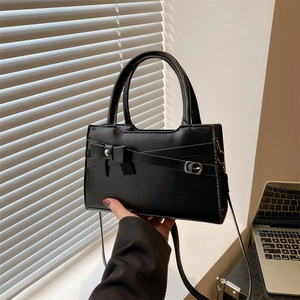 Minimalist black bow handbag with top handle and crossbody strap for office style