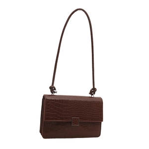 Brown crocodile pattern shoulder bag with silver buckle and knotted strap on white background