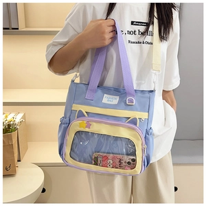 Detail of blue and purple tote bag featuring a clear PVC pocket and adjustable strap