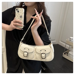 Detail of off-white baguette bag with dual pockets and metallic buckle accents