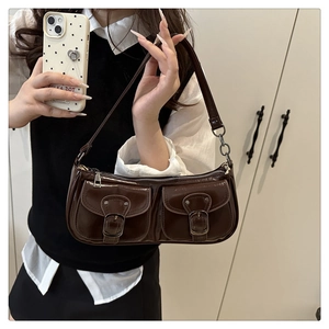 Deep brown patent leather shoulder bag with silver metal buckles shown in mirror selfie