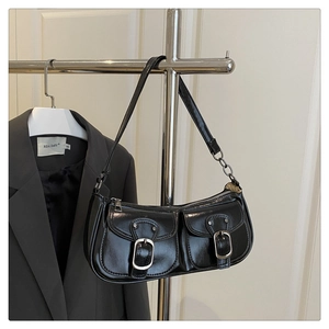 Close-up of black retro shoulder bag with dual pockets and silver metal buckles