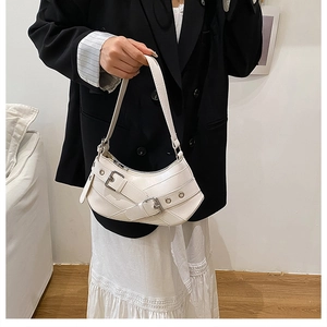 White crescent hobo bag with buckled leather straps and metallic eyelets detail