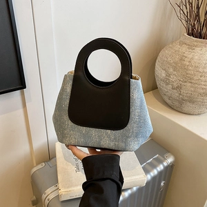 Contrast color bucket bag in blue denim with sparkling studs and round leather handles
