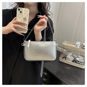 Close-up of silver crocodile embossed bag with metallic chain fringe and bead details