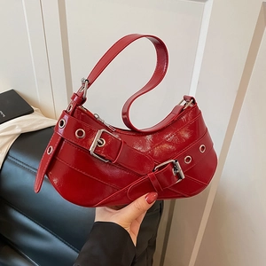 Red patent leather underarm bag with silver metal eyelets and punk style buckle straps