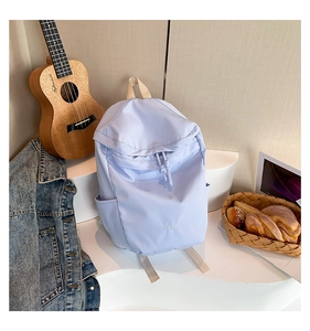 Detailansicht hellblauer wasserdichter Nylon-Rucksack mit Seitentasche und Stickerei