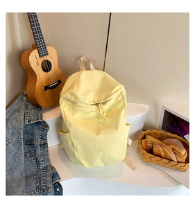 Detail eines hellgelben Rucksacks mit wasserabweisendem Stoff und Seitentasche im Freizeitlook