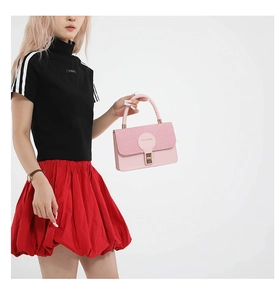 Dettaglio della borsa rosa con patta a trama intrecciata e chiusura in metallo oro