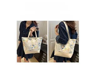 Detail of embroidered floral tote bag showing handheld and shoulder carrying styles