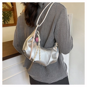 Detalle de bolso de hombro plisado plateado con relieve de moda y colgante de corazón