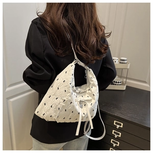Detail of white puffy moon bag featuring black rabbit print and cute bow decor