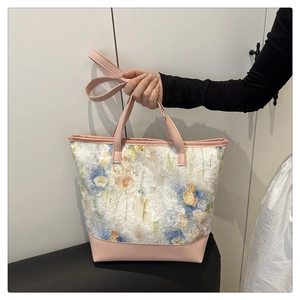 Detailed view of floral lace tote bag featuring pink leather handles and floral patterns