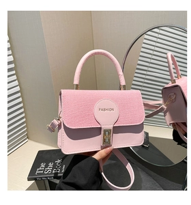 Dettaglio della borsa a scatola vintage rosa con trama in tessuto e chiusura dorata