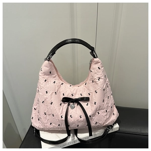 Close-up of pink pleated tote with black K embroidery and silver heart charm detail