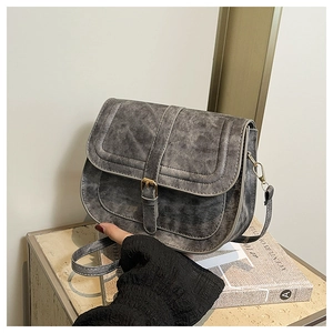 Detailed view of vintage gray denim saddle bag with metal buckle and adjustable shoulder strap