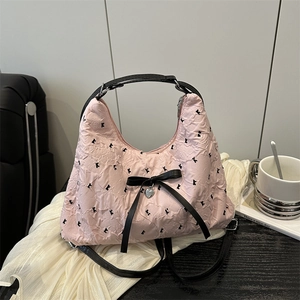 Pink pleated hobo bag with black letter print, bow detail, and silver heart charm