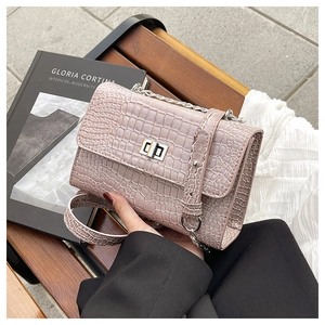 Detail of lavender croc-effect handbag with silver twist lock and chain strap