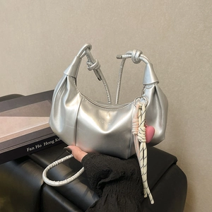 Bolso de media luna plateado metalizado con diseño plisado y colgante de corazón