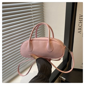 Detailansicht einer rosa Mini-Bowling-Tasche aus Glanzleder mit Griffen und Schultergurt