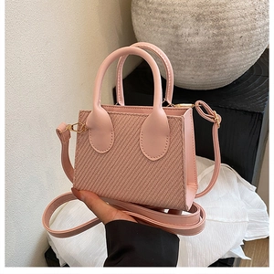 Detailed view of pink mini crossbody bag featuring twill weave texture and strap