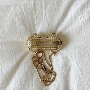 Pochette dorata a forma di arachide con strass luccicanti e sottile catena a serpente