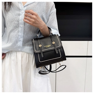 Detail of black vintage satchel with white beaded trim and gold buckle accessories