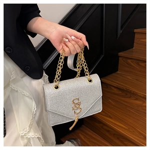 Detail of silver sequin bag with gold SS logo, fringe tassels and elegant chain strap