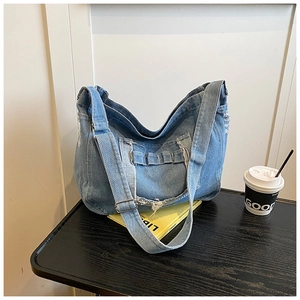 Détails du sac en jean bleu clair avec bords à franges et boucle métallique ajustable