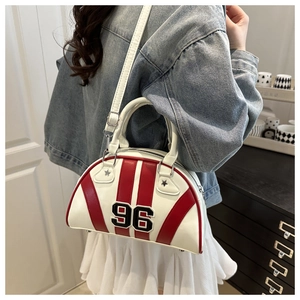 Détail du sac bowling à rayures rouges et blanches avec patch 96 porté par le mannequin