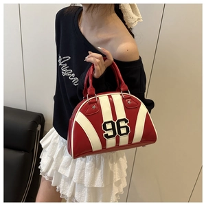 Détail du sac bowling rayé rouge et blanc avec écusson numérique 96 et rivets étoiles