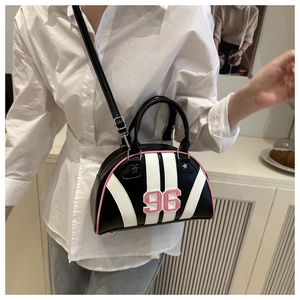Detail of trendy bowling-style shell bag with number 96 patch and pink trim accents