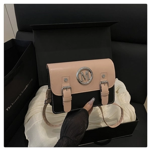 Detail of two-tone square bag featuring silver M logo on a premium silk lining