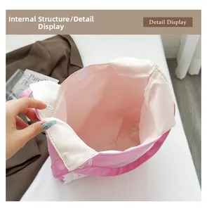 Vista detallada del bolso de lona rosa con ribete de encaje blanco y forro interior amplio