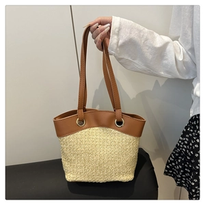 Close-up of woven straw texture and brown leather strap with gold ring attachment