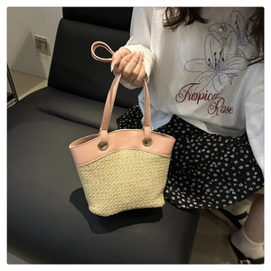 Detail of pink leather handles and fine straw weaving on the large tote beach bag