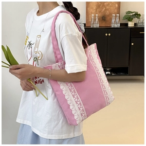 Gros plan sur le sac cabas en toile rose avec des décorations verticales en dentelle