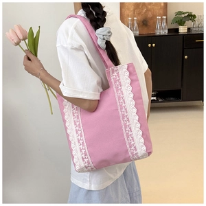 Détail du sac cabas en toile rose avec bordure délicate en dentelle blanche sur les côtés