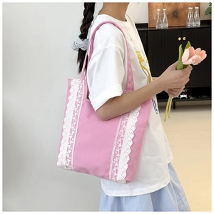 Détail du sac cabas en toile rose avec bordure en dentelle blanche et doubles bretelles