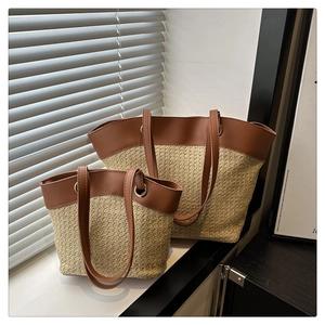 Detail of two-piece straw tote bags with brown leather trim and golden metal rings