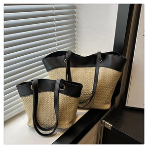 Detail view of two-piece patchwork straw tote bags with black leather handles and metal eyelets