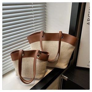 Detailed view of two-piece French vintage straw woven tote bags with brown leather handles