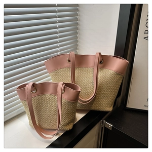 Detail of straw woven tote set in large and small sizes with pink leather trim and handles