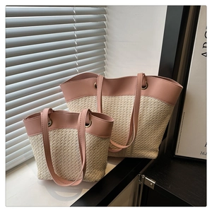 Detailed set of two woven straw tote bags with pink leather straps in a bright room
