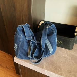 Grand sac messager en denim bleu foncé avec détails effilochés et bandoulière réglable
