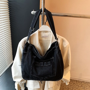 Sac bandoulière en jean noir avec franges, coutures contrastées et poche frontale