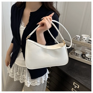 Detail of white PU leather baguette shoulder bag with gold metal buckle and slim strap