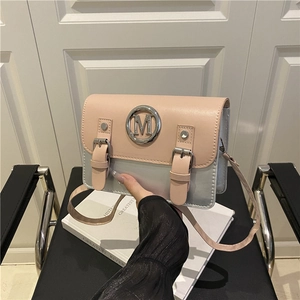 Pink and silver contrast crossbody bag with metal M logo on a modern shoulder bag