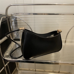 Chic black minimalist hobo bag with sleek curved design and gold hardware accents