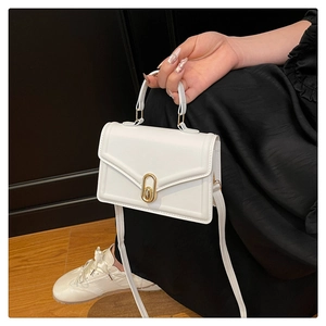 Detailed view of a white PU leather shoulder bag featuring a golden oval twist lock clasp